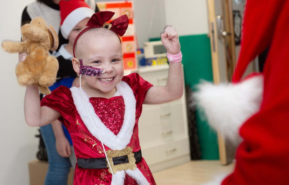 Florence Bark, 6, beams after getting a present from Santa – one of hundreds donated to our neediest children by Sun On Sunday readers