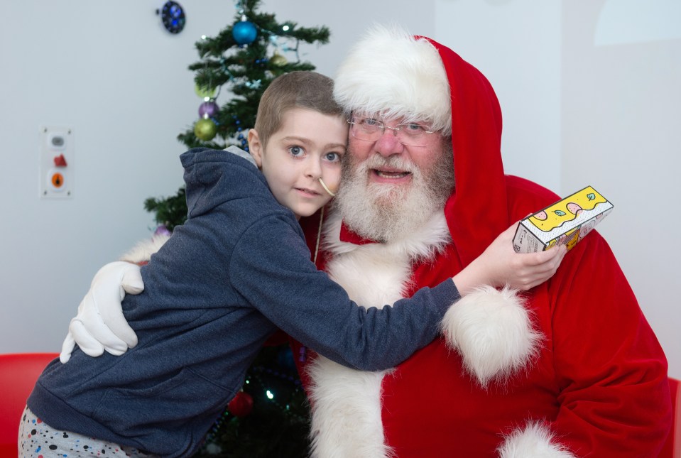 Gianluca Fattore was so delighted to meet Santa and receive a board game that he kept cuddling him