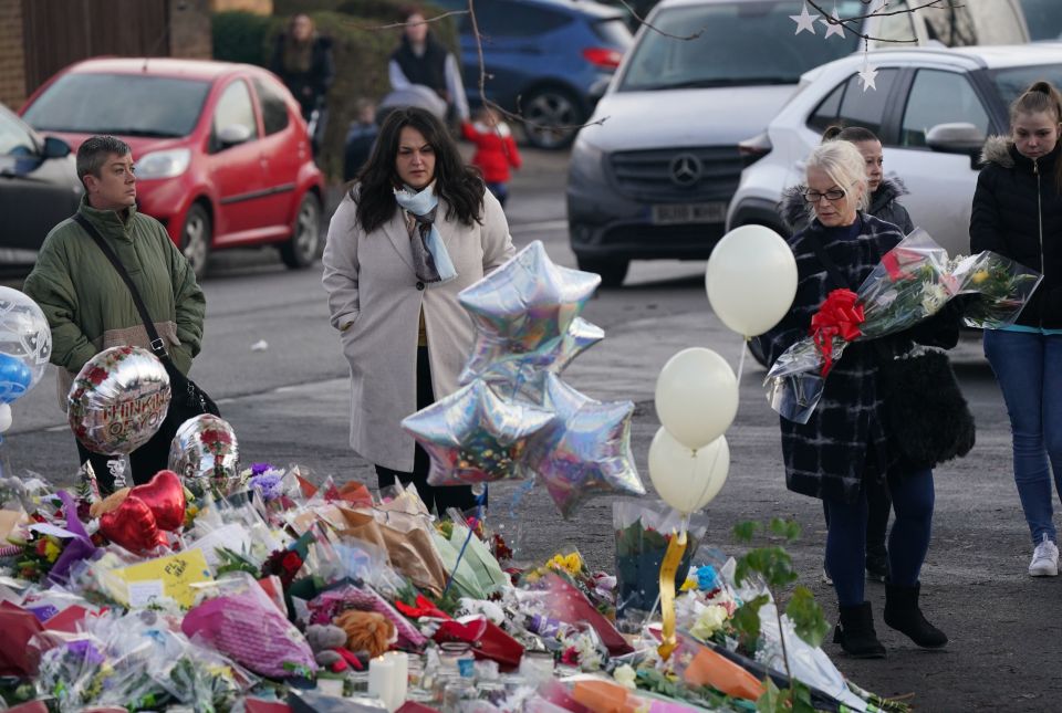 People bringing flowers and tributes near to Babbs Mill Park