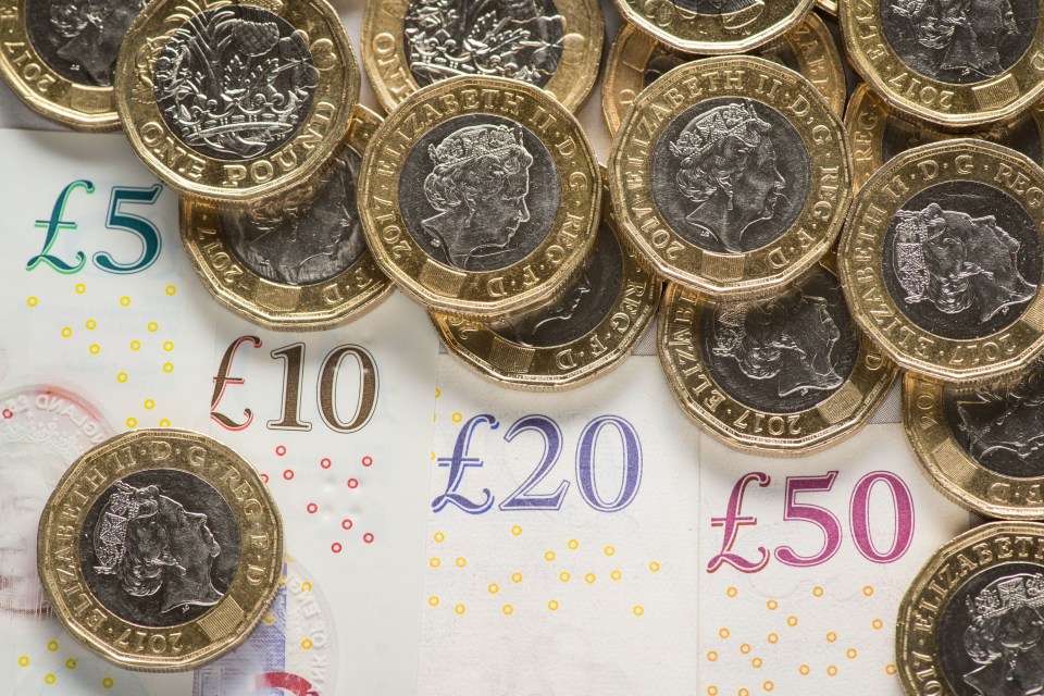 a pile of coins on top of a pound note