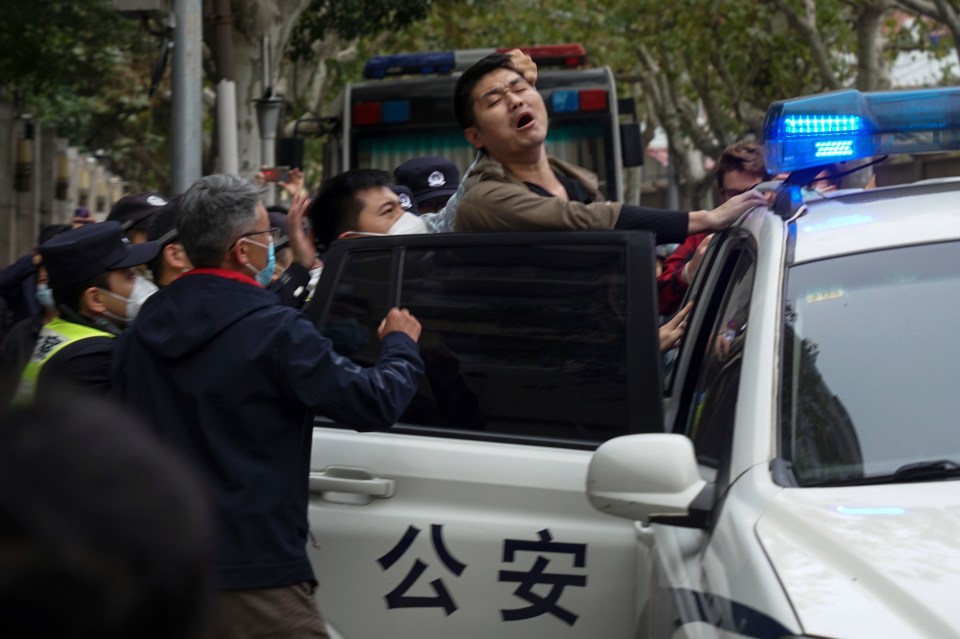 A protester being taken away by cops in Shanghai, China