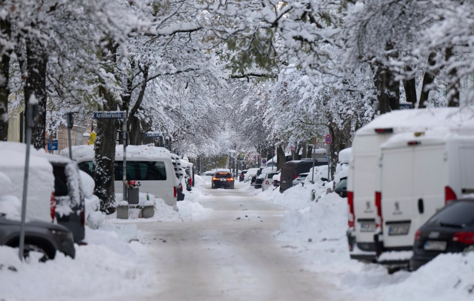 Cars driving on a snow-covered road in Munich.