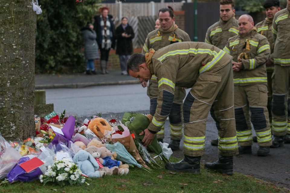 Firefighters leave tributes for the dead children near the scene