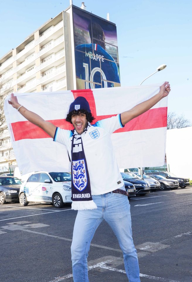 Sun reporter Joe Hadden flies the England flag in front of an apartment block in the neighbourhood of Bondy, Paris suburb where Kylian Mbappe grew up