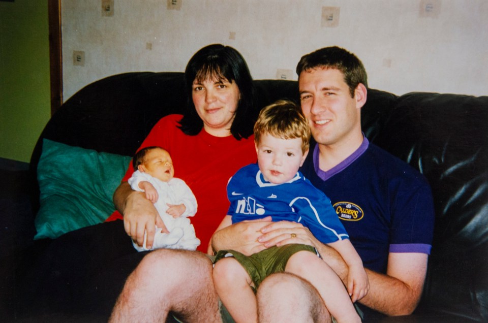 a family sitting on a couch with a man wearing a shirt that says quality