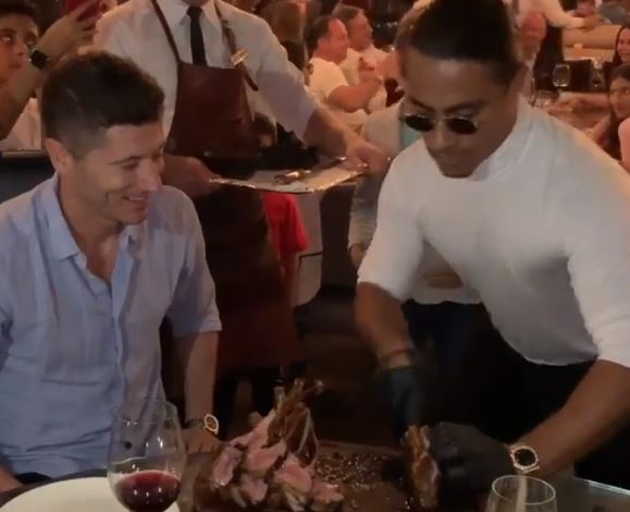 Salt Bae can be seen gyrating back and forth as he serves Robert Lewandowski