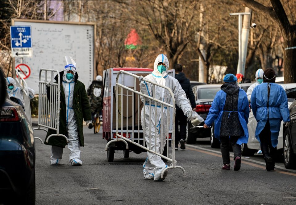 A lockdown enforcer removing a barrier from an area freed from lockdown