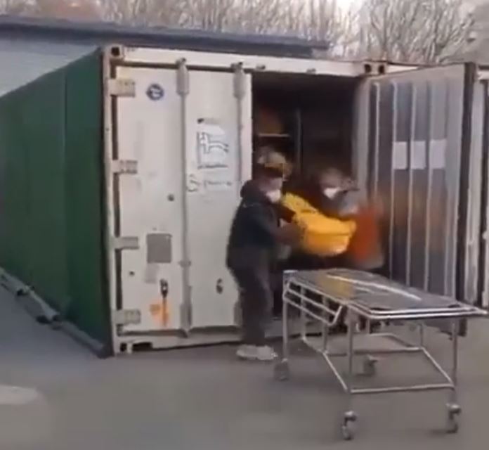 A body being unloaded from a shipping container