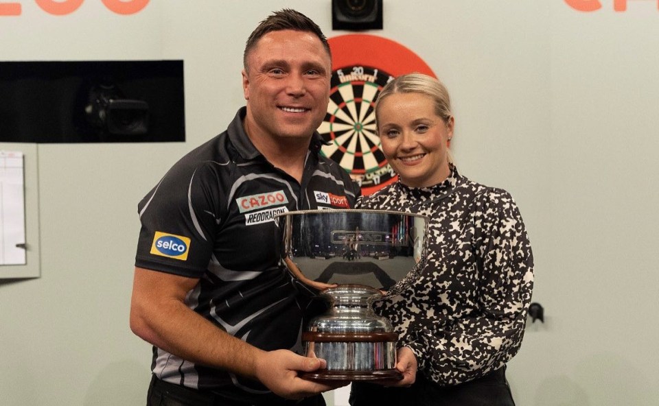 Gerwyn Price and his wife, Bethan Palmer, holding a trophy.