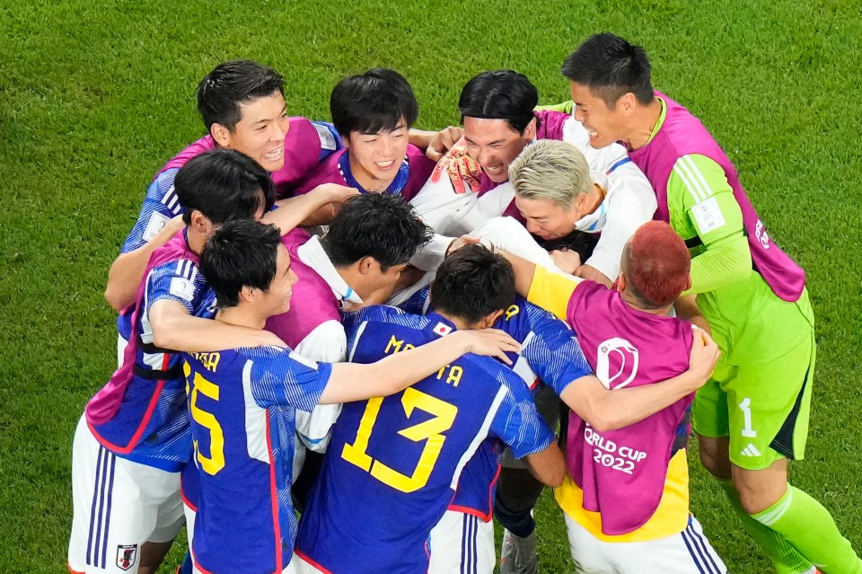 Japan players celebrate their second goal against Spain