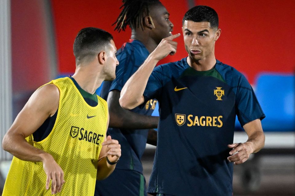 Cristiano Ronaldo points out he's still the man for muscles as Diogo Dalot looks on in Portugal training in Al Samriya, Doha