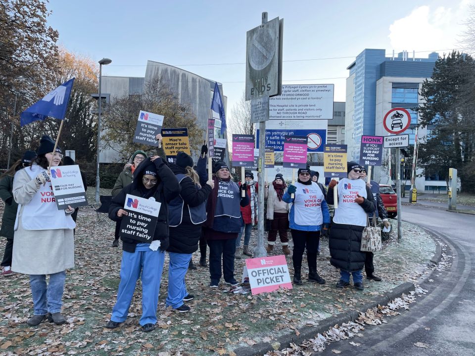 Nurses held up signs outside University Hospital Wales in Cardiff today