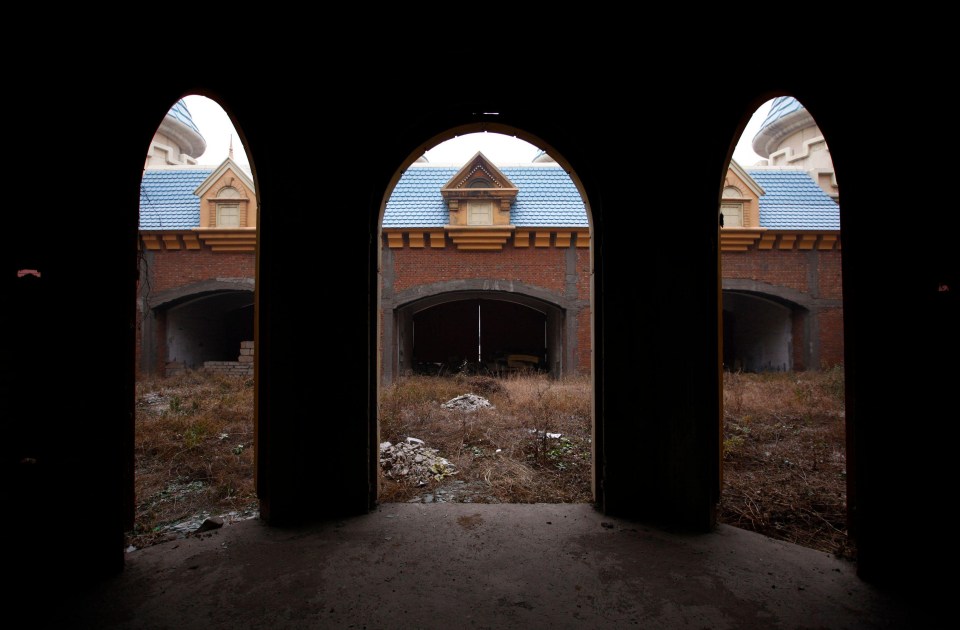 a dark room with arches and a blue roof