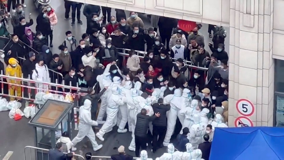 Shanghai residents confront hazmat-clad enforcers during a protest