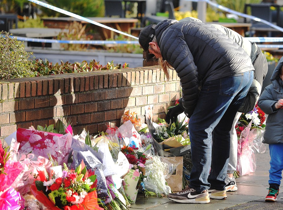 He read the many floral tributes left against a wall for Elle