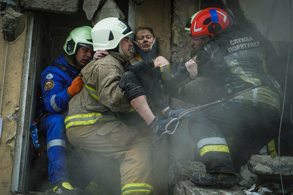 A woman is pulled from smoky rubble – she is among around 39 others who were rescued, including children