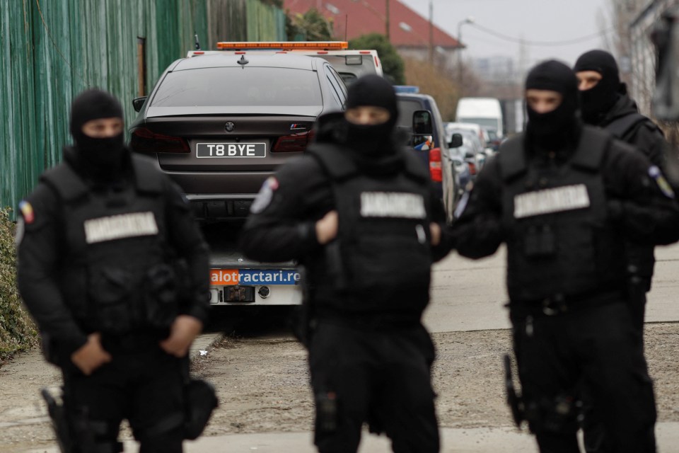 Police remove a car with a 'T8 BYE' plate