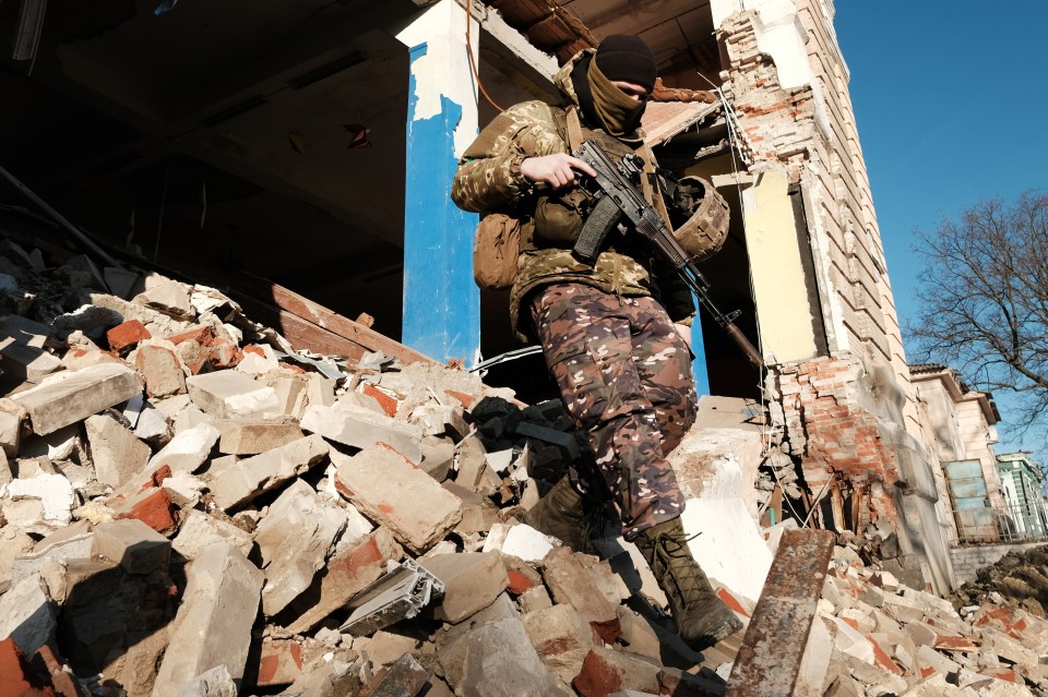 Ukrainian soldiers walk over rubble in a destroyed building after testing a drone in Kupiansk, Ukraine