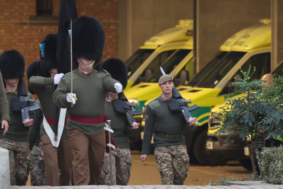 Soldiers march near ambulances parked at Wellington Barracks in central London during strike action