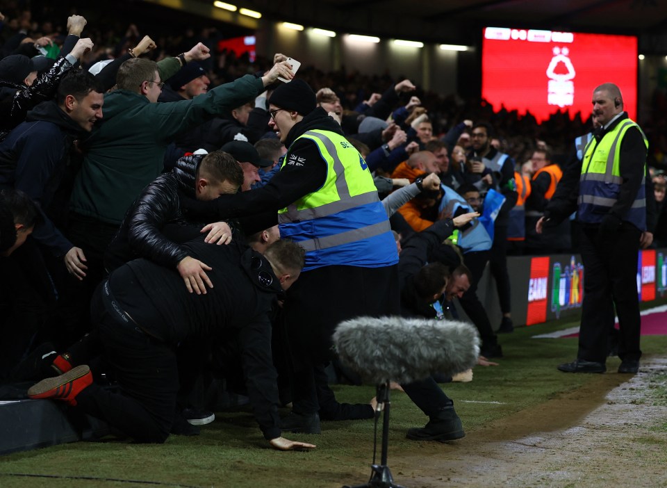 Supporters tumble over each other as the boards give way