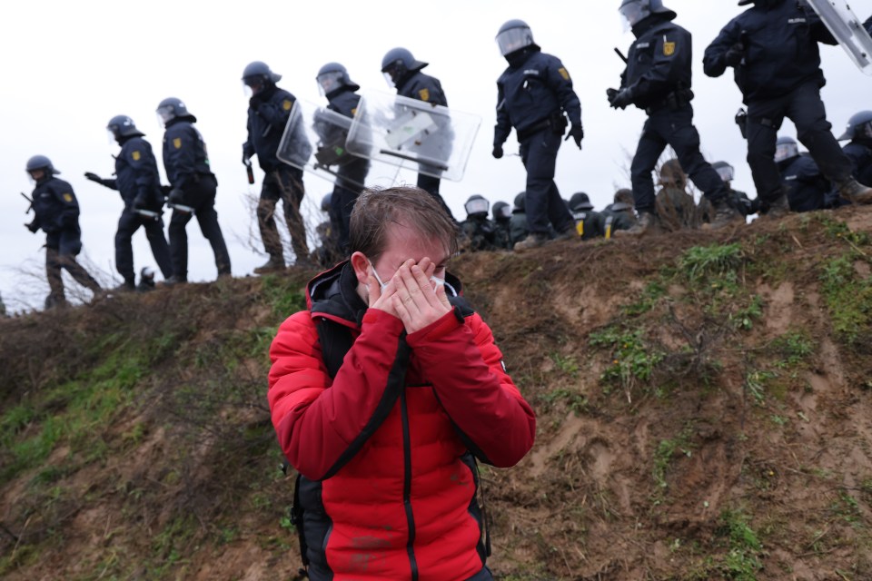 A protester holds his hands to his after being peppersprayed