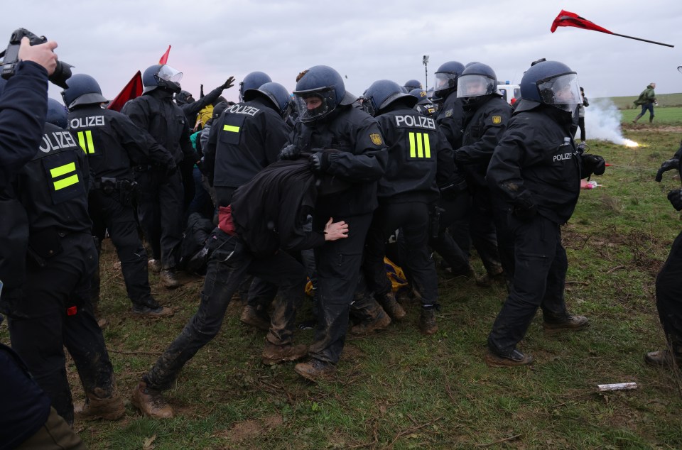 Police in riot gear scuffle with protesters