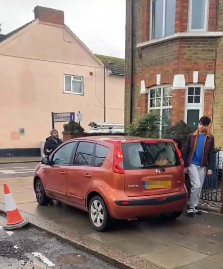 An angry pedestrian trying to force a driver on the pavement to reverse