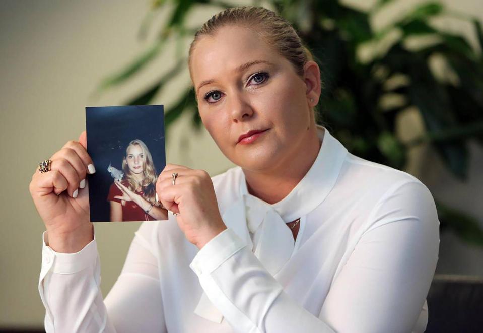 Virginia Roberts holds up a picture of herself as a teen