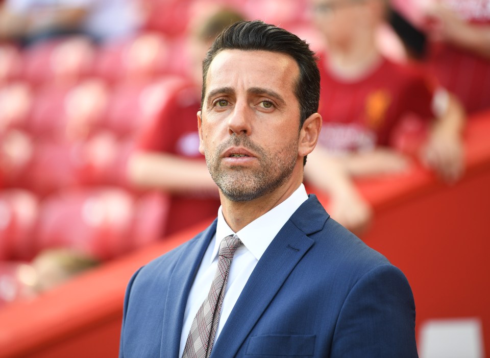 a man in a suit and tie stands in a stadium