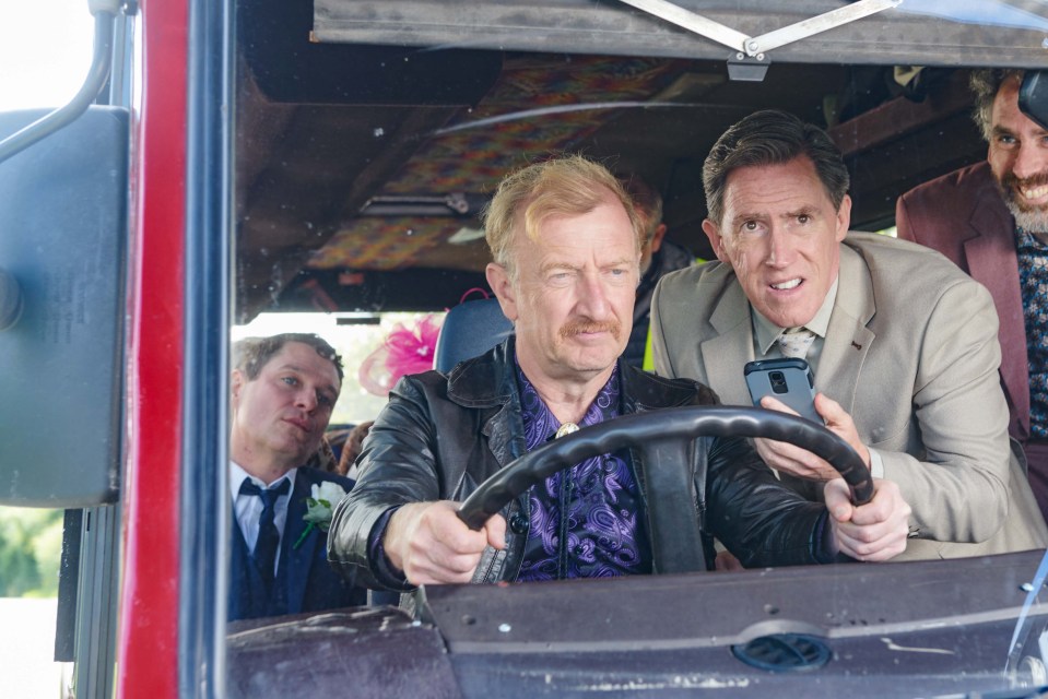 Rob Brydon and Mathew Horne in a car with other passengers.