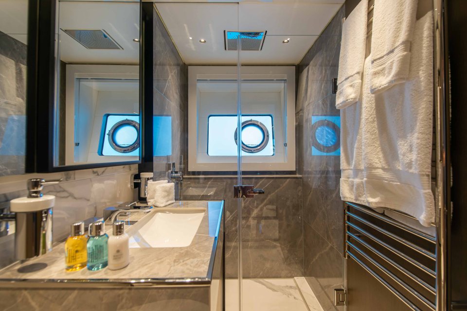 The bathroom is fully kitted out with a window that looks out to sea from the shower