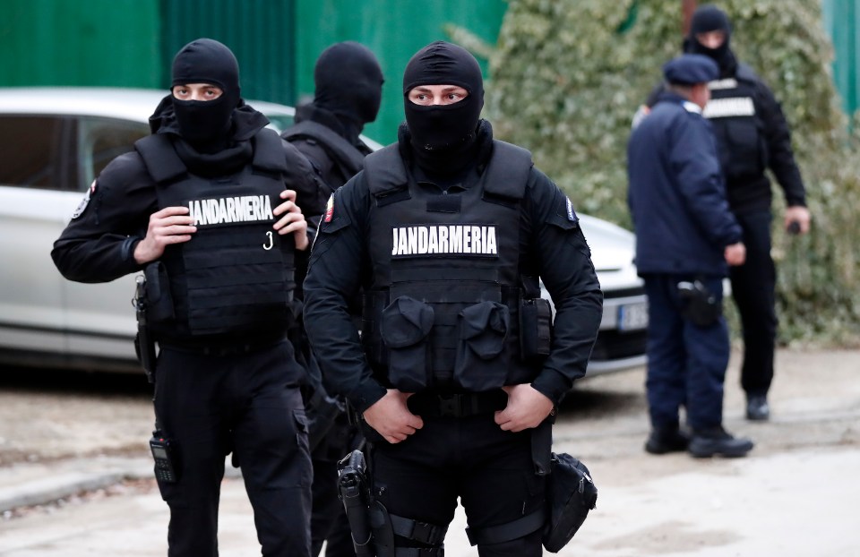 Police wearing balaclavas work on the scene in Bucharest