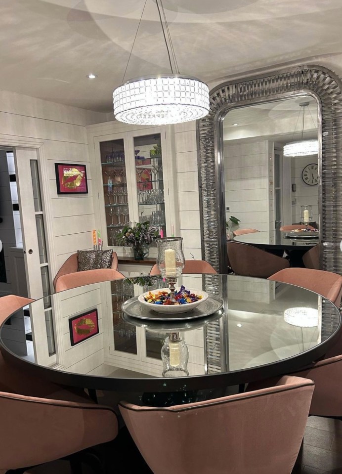 Her mirrored dining table matches the silver-framed decor on the wall