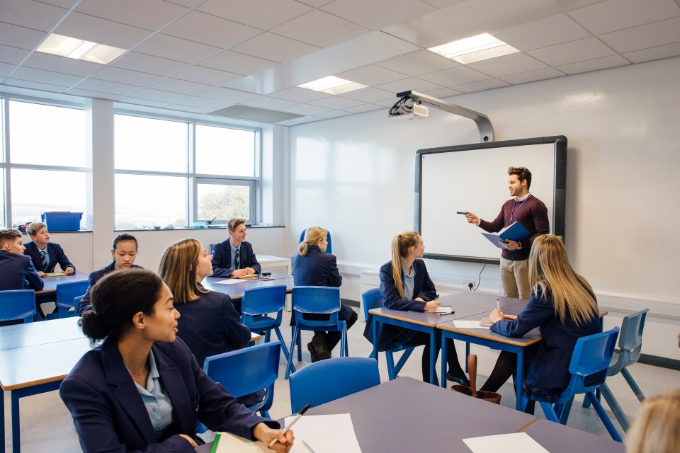 Male teacher is teaching a group of teenagers in a high school lesson.