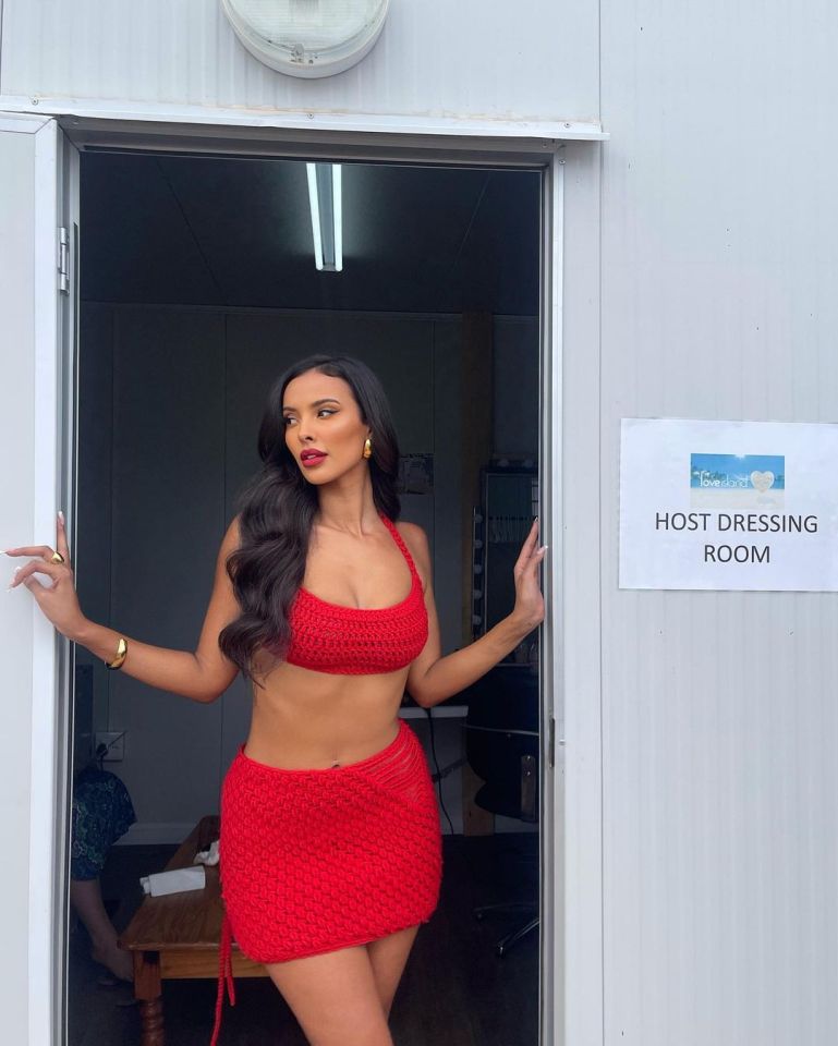 Maya Jama in a red crochet outfit outside a Love Island host dressing room.