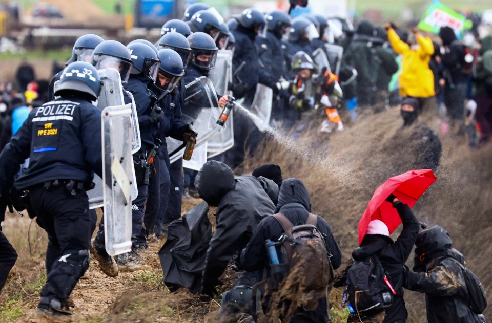 Police officers spray activists during clashes