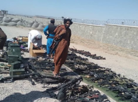 Taliban fighters pose with their hauls of US-made weapons