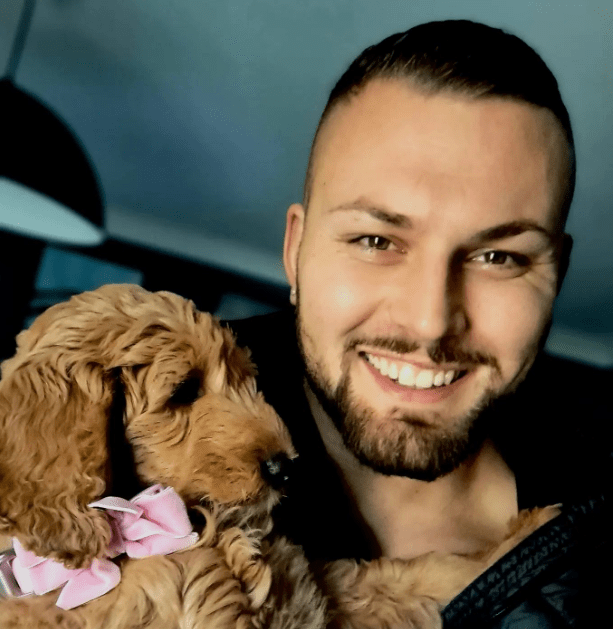 The personal trainer can also be seen cuddling his dog Ruby, which is a Golden Doodle dog