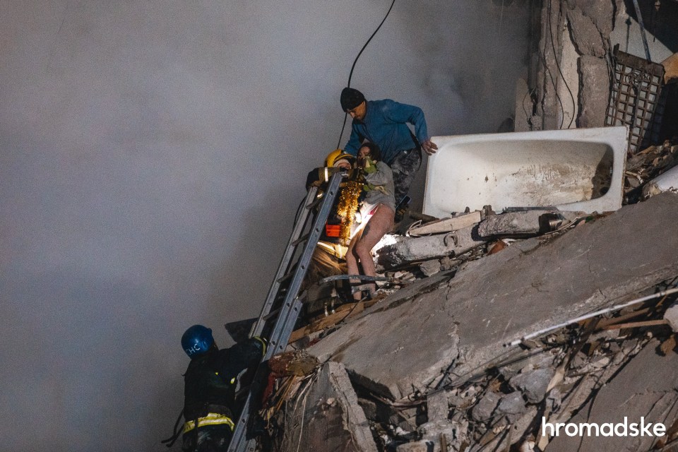 Anastasia Shvets is helped to safety by emergency rescuers who have been working tirelessly to find survivors