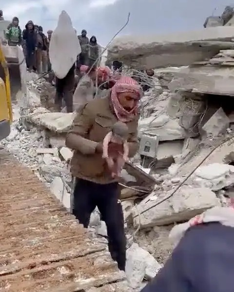 A baby girl is taken from the rubble of Jenderes for treatment in hospital