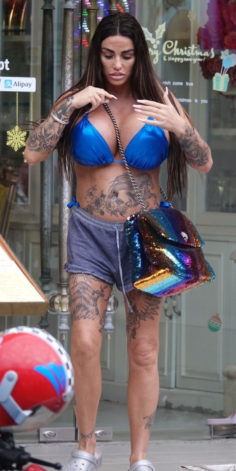 Katie's blue bikini and shorts showed off her heavily tattooed torso