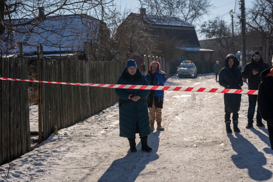 Residents wait behind police cordon to return to their homes after a rocket attack in Kyiv