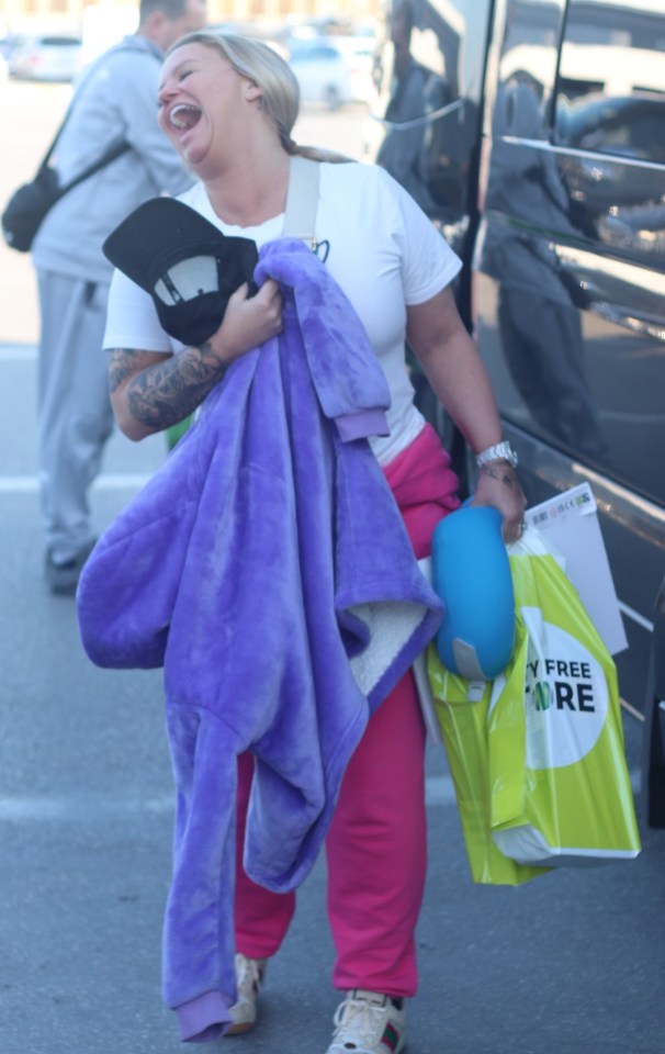 She was seen touching down with a sleep pillow and a Duty Free bag