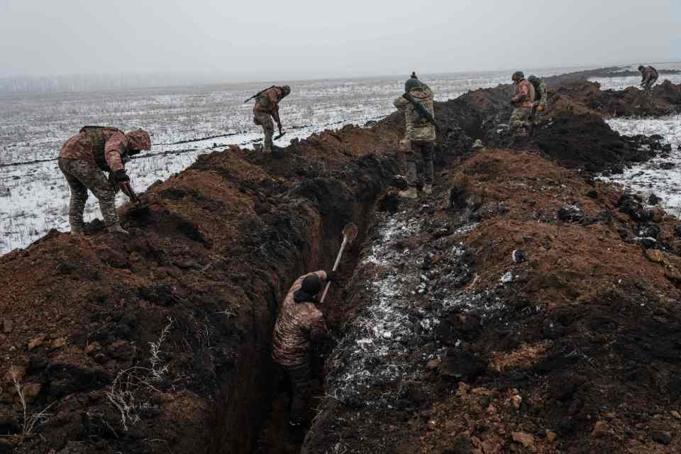 Ukrainian servicemen dig a trench near Bakhmut