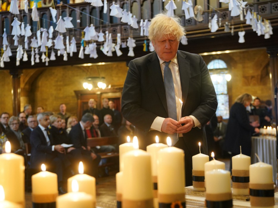 Former PM Boris Johnson lights one of 52 candles - one for each week of the war - during an ecumenical prayer service at the Ukrainian Catholic Cathedral in London