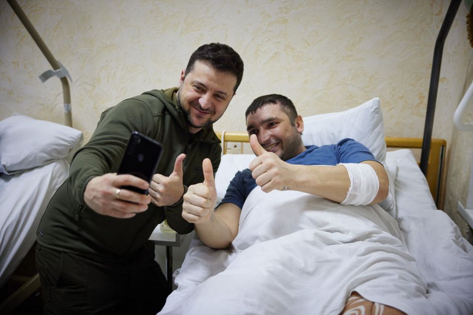 Zelensky takes a selfie with an injured soldier