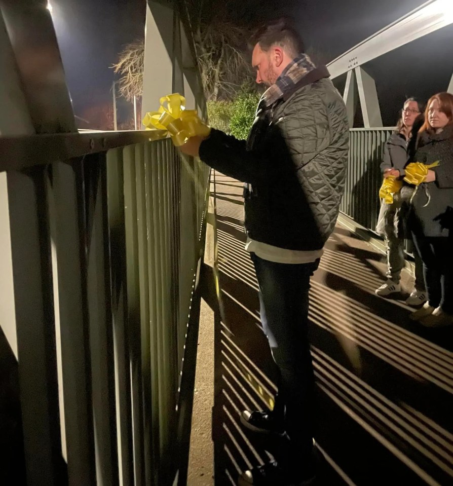 Nicola's partner Paul ties a yellow ribbon to the bridge over the River Wyre