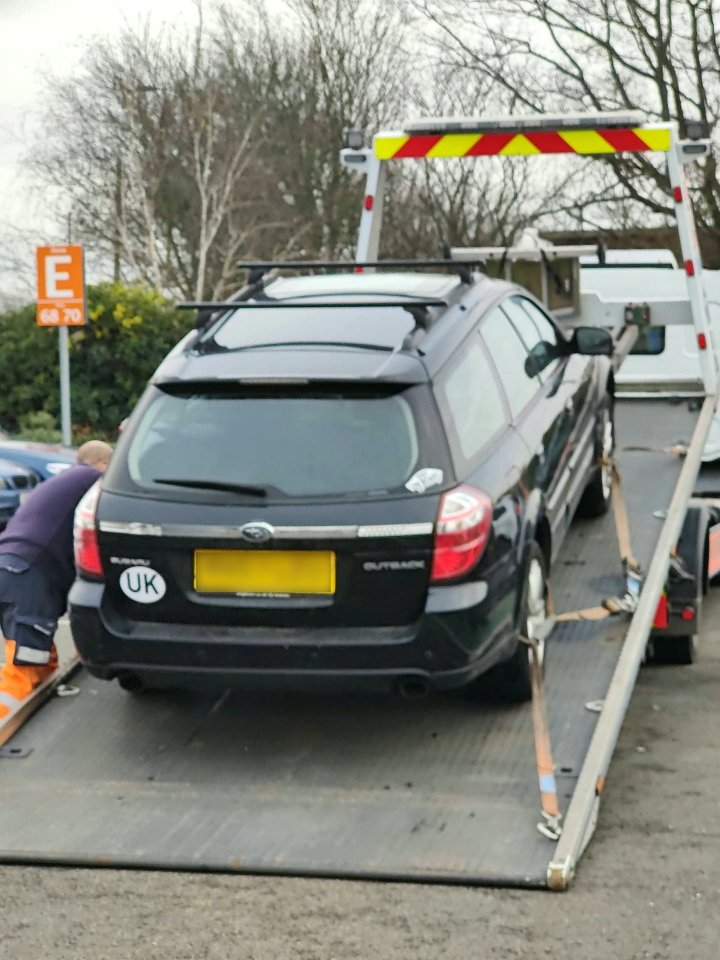 The ruined car being towed away