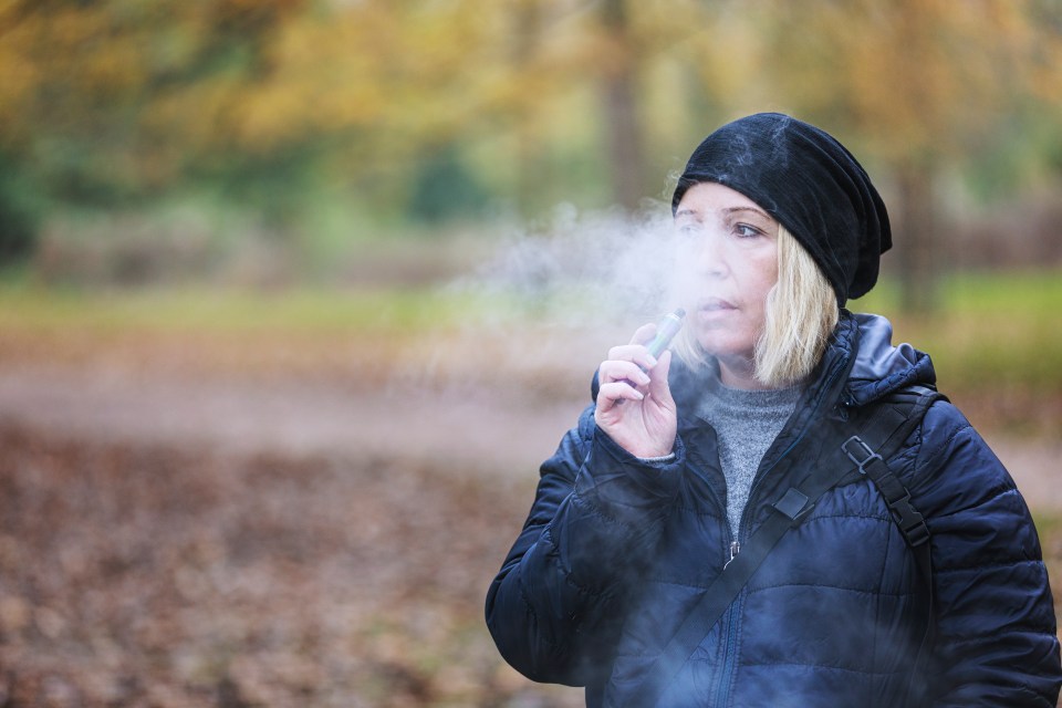 Caucasian woman vaping and exhaling a cloud of smoke shot with selective focus