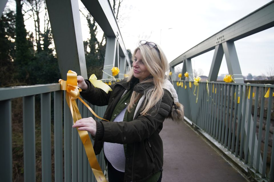 Nicola's next-door neighbour Charlotte Drake ties a yellow ribbon to a bridge over the River Wyre